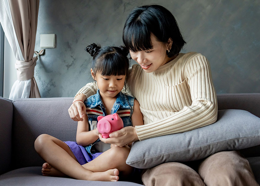 Mom, daughter and piggy bank